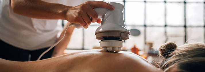 Vibration Muscle Therapy Device Being Used On Someone's Back