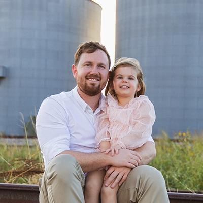 Chiropractor Taylor Davis With His Daughter Sitting Outdoors